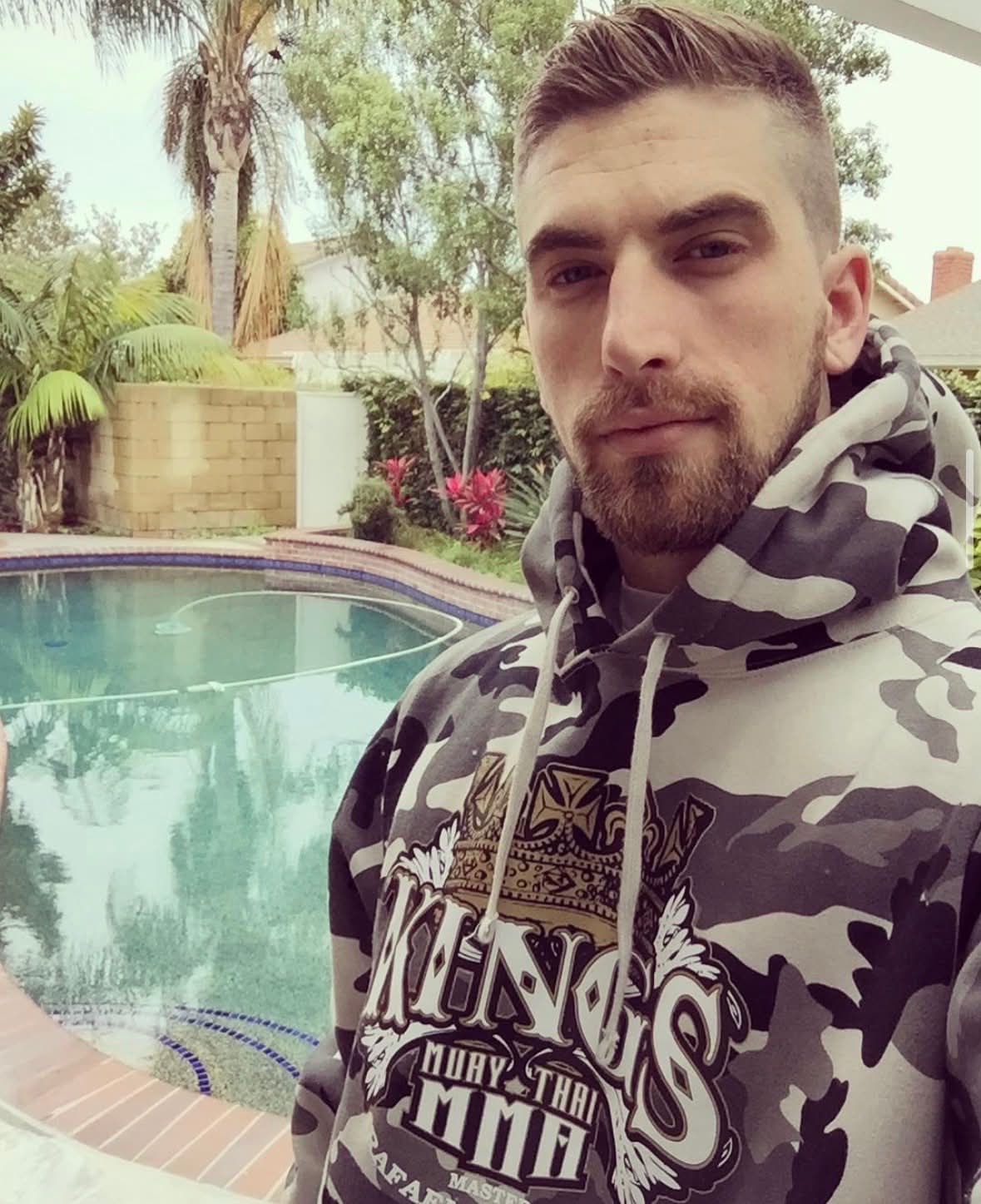 Steve wearing a camouflage hoodie beside a swimming pool