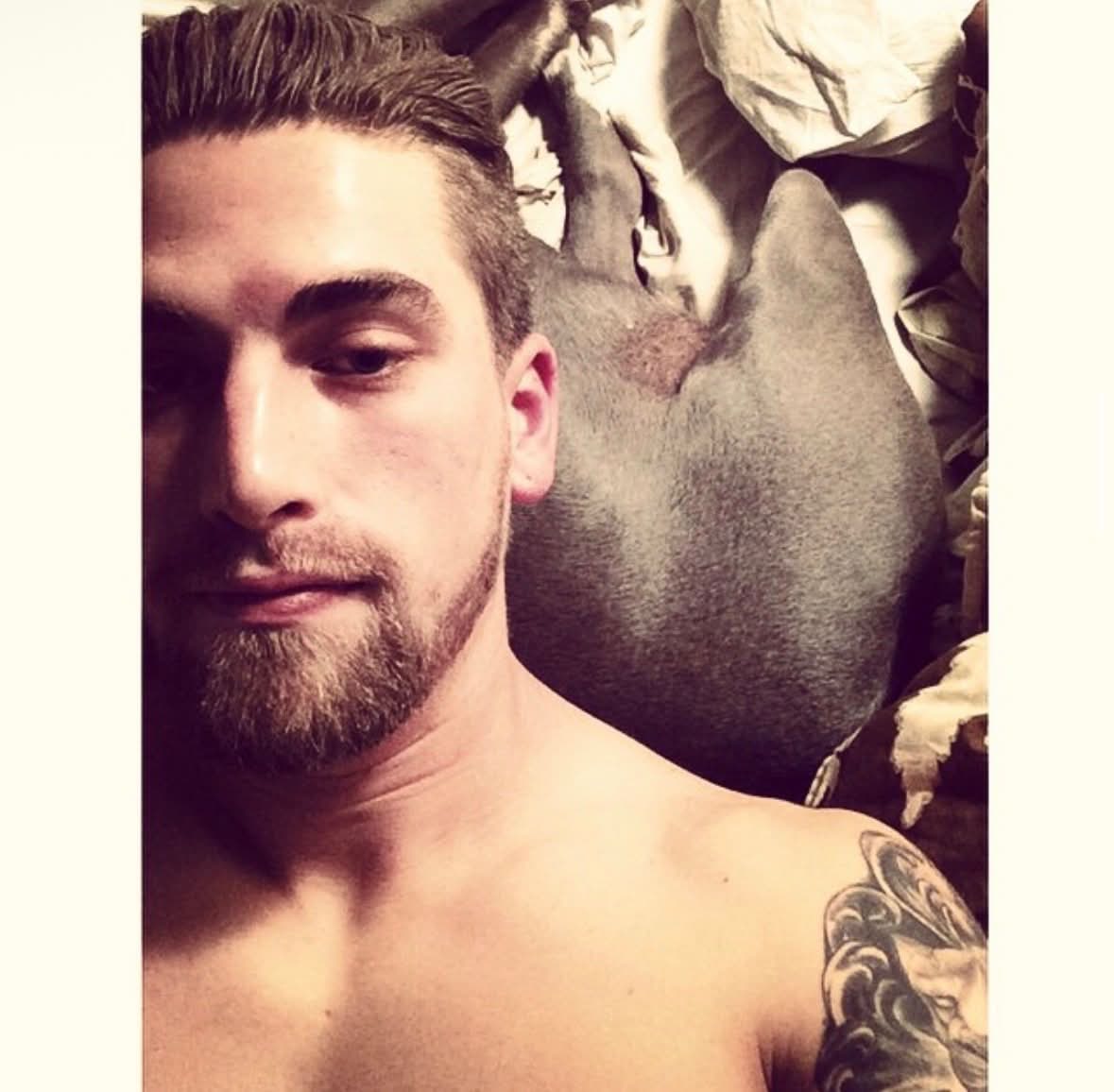 Steve relaxing with a dog behind him